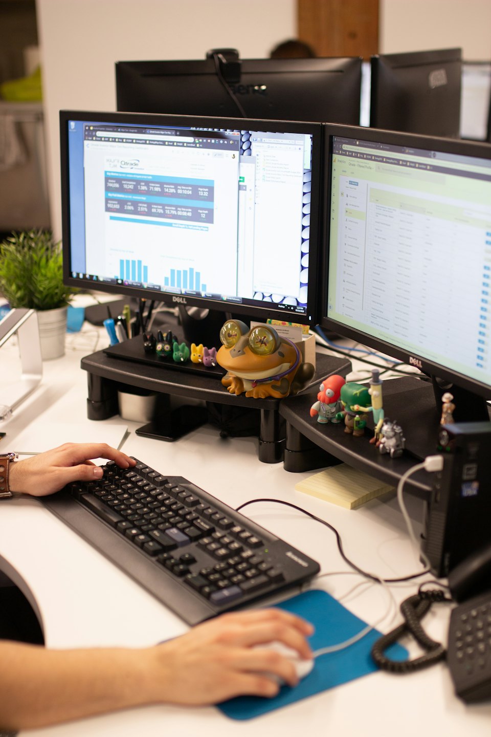 Hands typing on a keyboard next to a computer mouse on a desk.